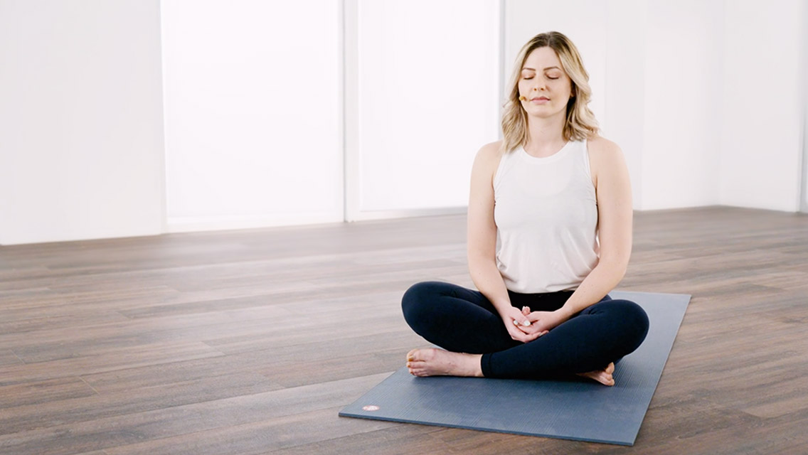 Woman sitting on a yoga mat meditating