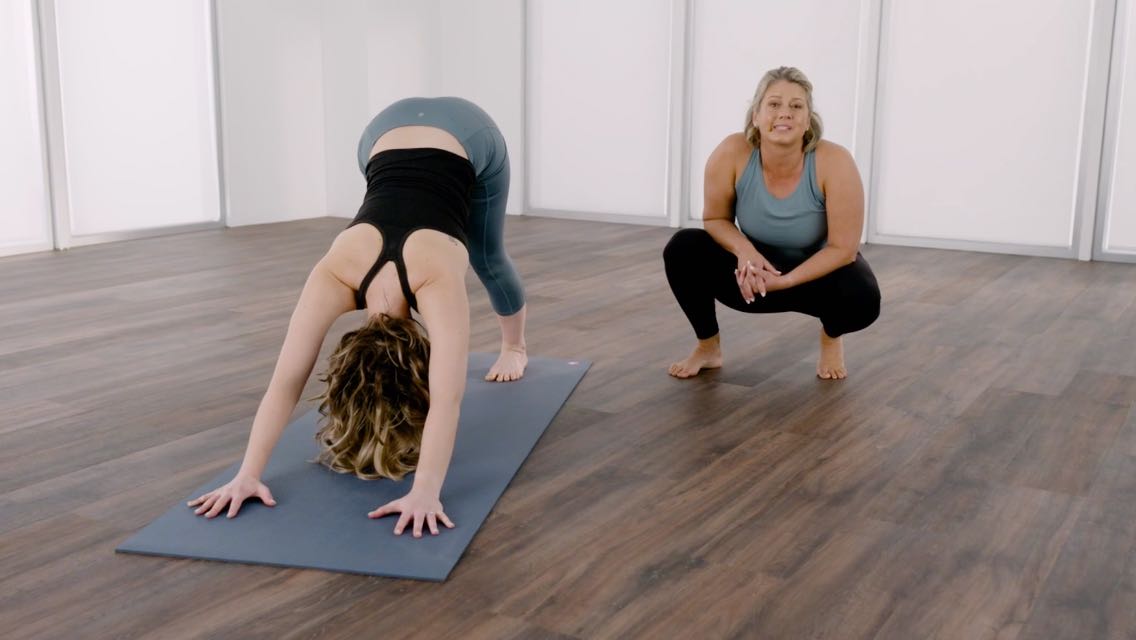 Woman holding a downward dog position on a yoga mat
