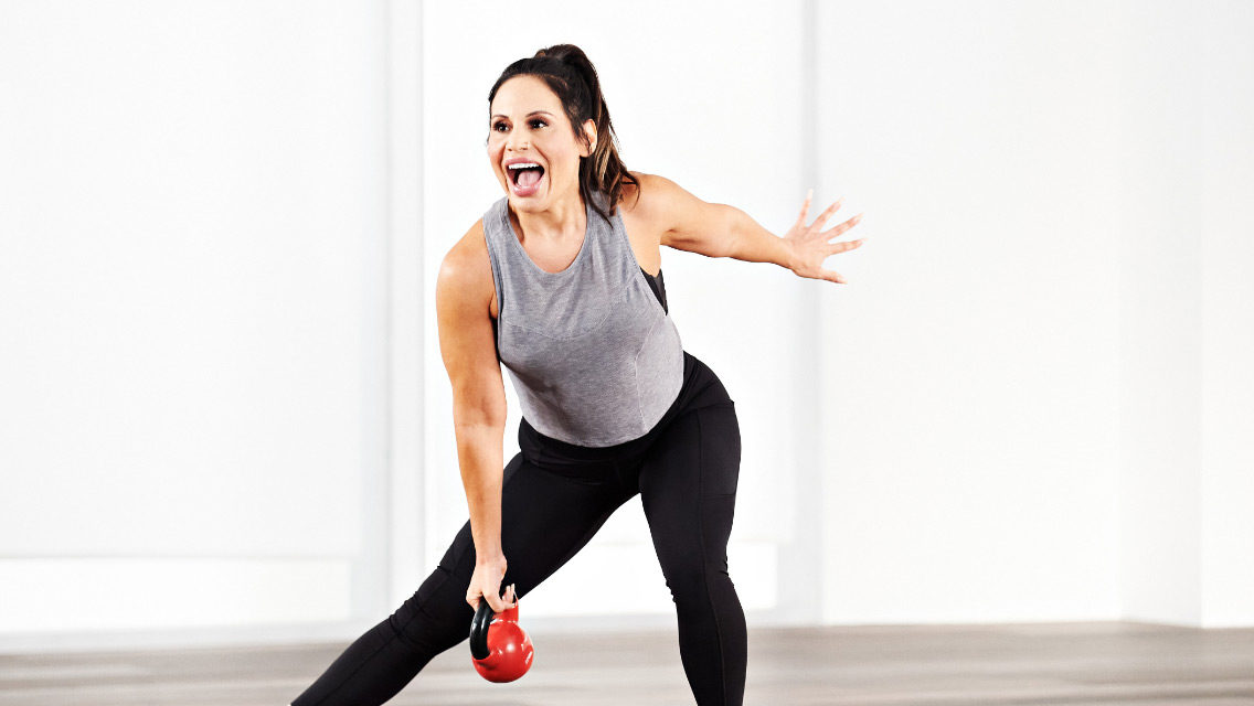 a woman performs a side lunge while holding a kettlebell