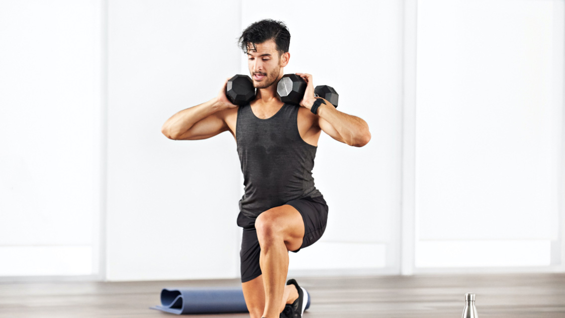 a man performs a lunge with dumbbells