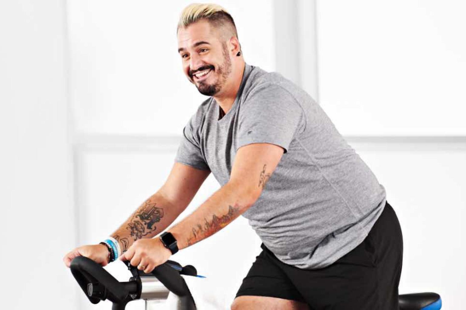a man participates in a studio cycle class at home