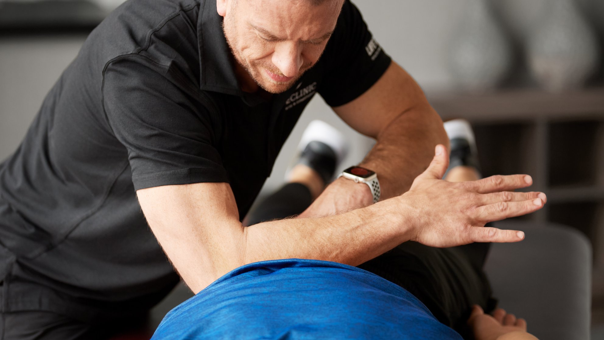 chiropractor adjusting a man's back