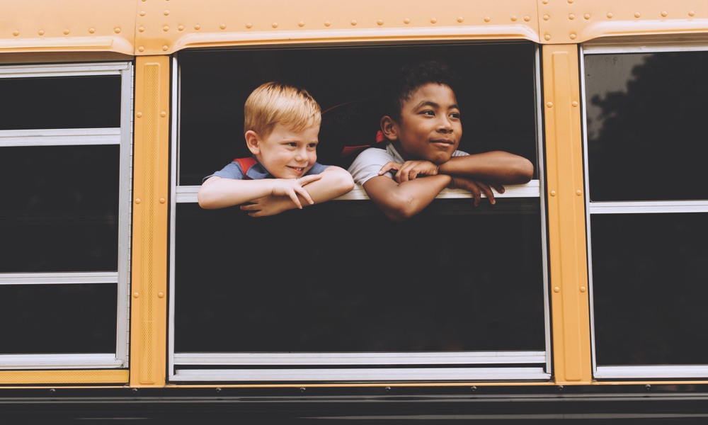 two kids riding on a bus