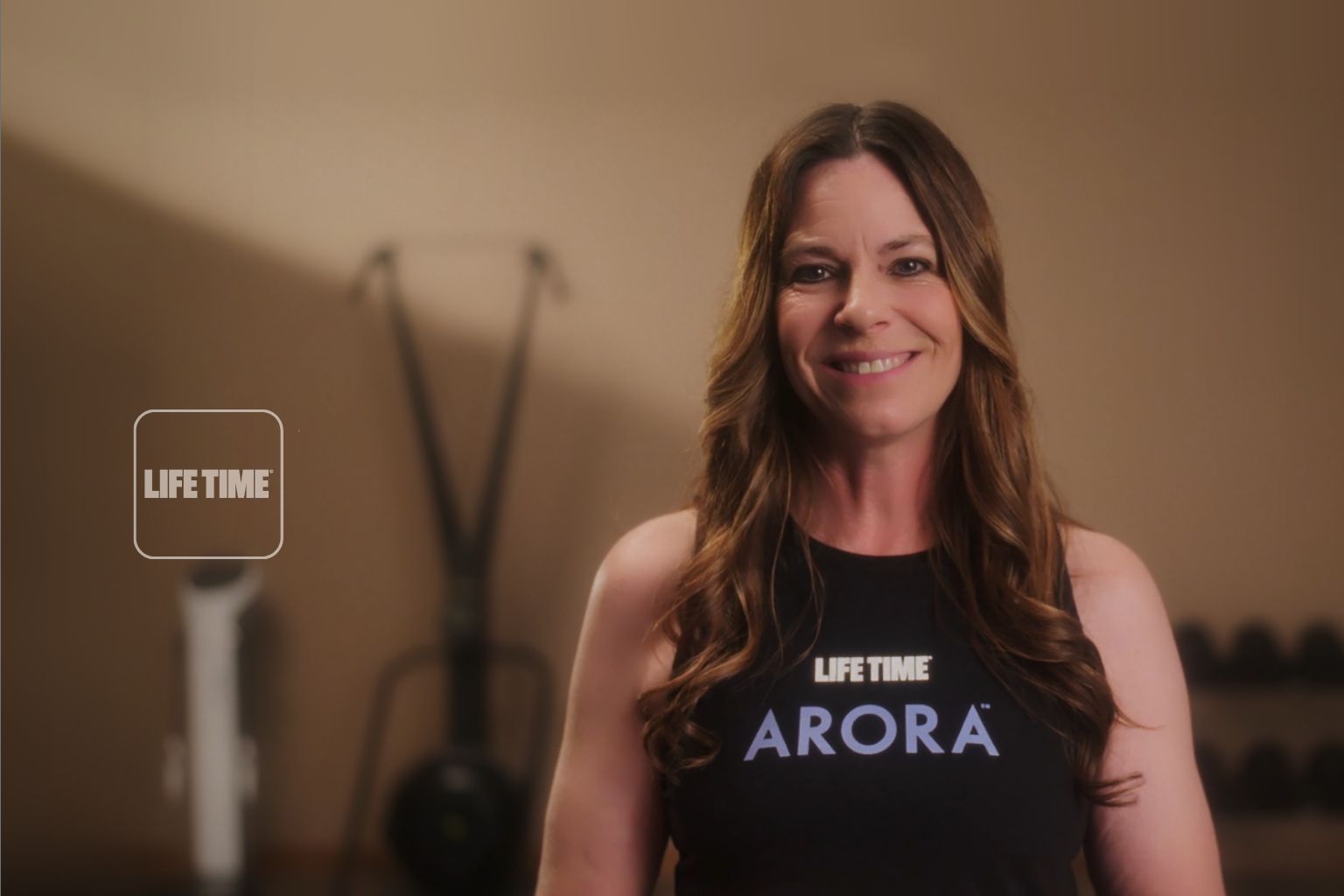 a woman smiling in a black arora tank top