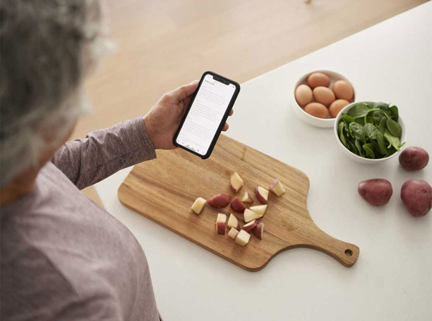 a woman looking at her phone and a table with vegetables