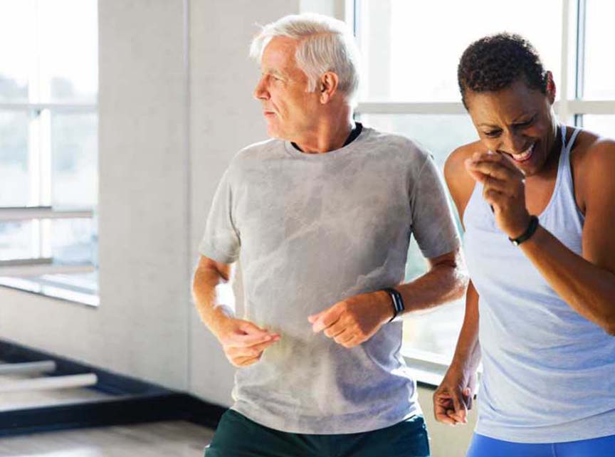 A man and woman dance in a Life Time studio. 