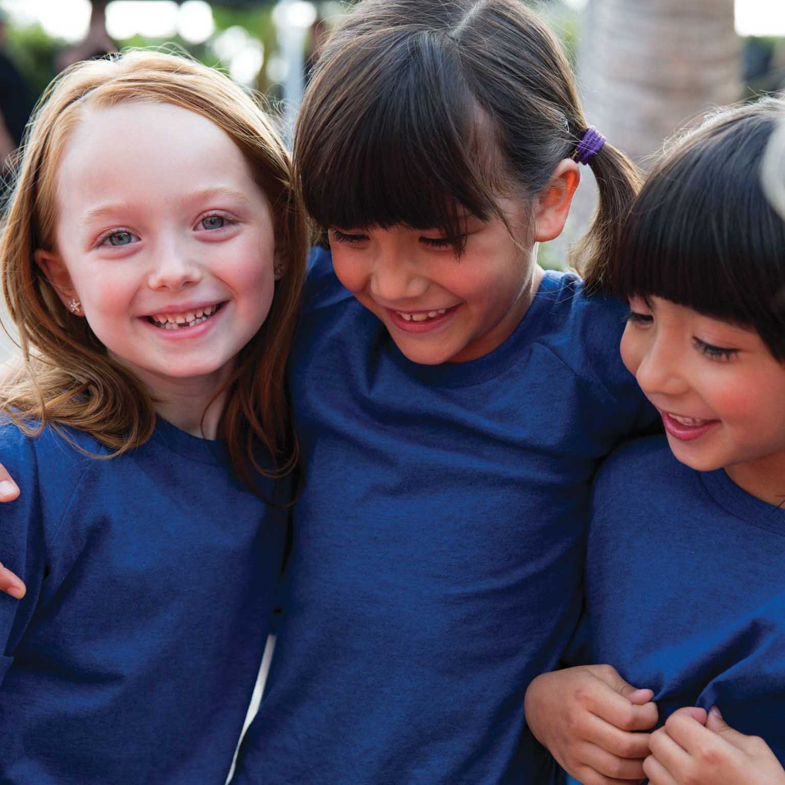 four young kids with their arms around one another