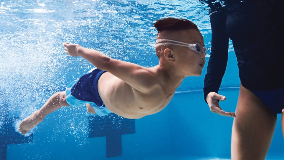 a child swimming underwater with an instructor