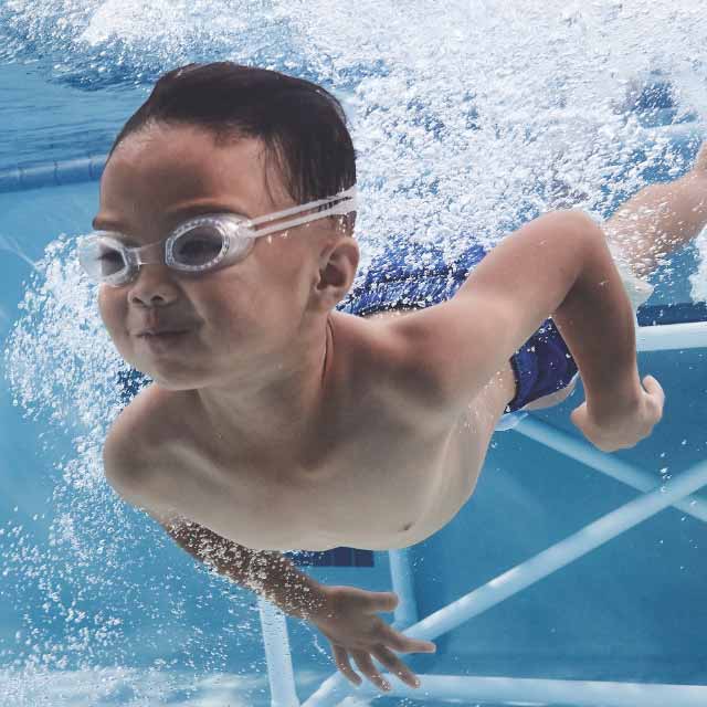 a young boy swims underwater