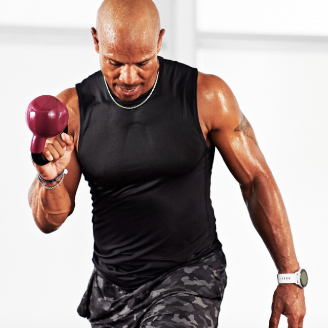 Man taking a Kettlebell class at home with Life Time Classes On Demand