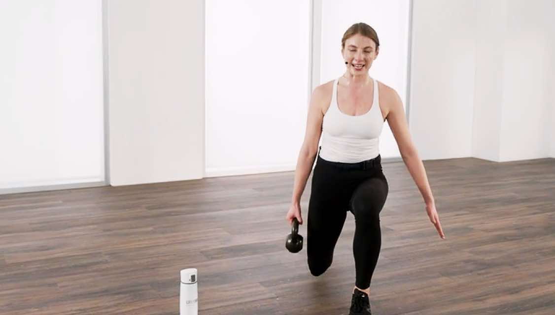 a woman preforms a move with a kettlebell