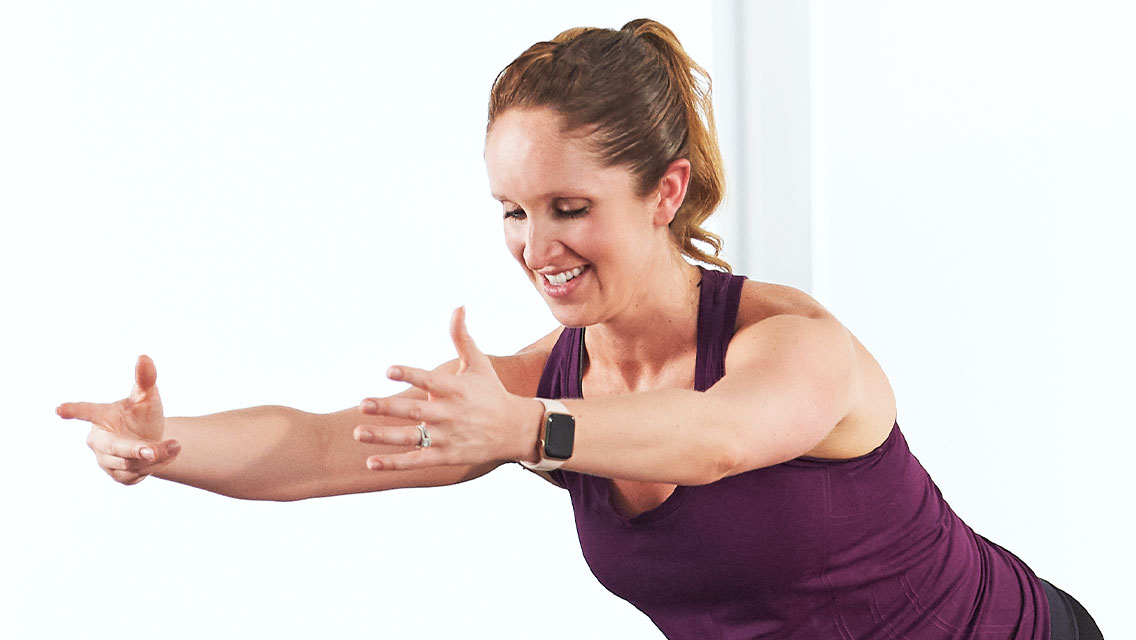 a smiling woman squats while holding a her arms out