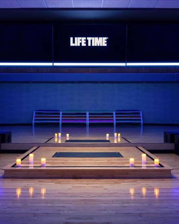 A dimly lit yoga studio with candles lit
