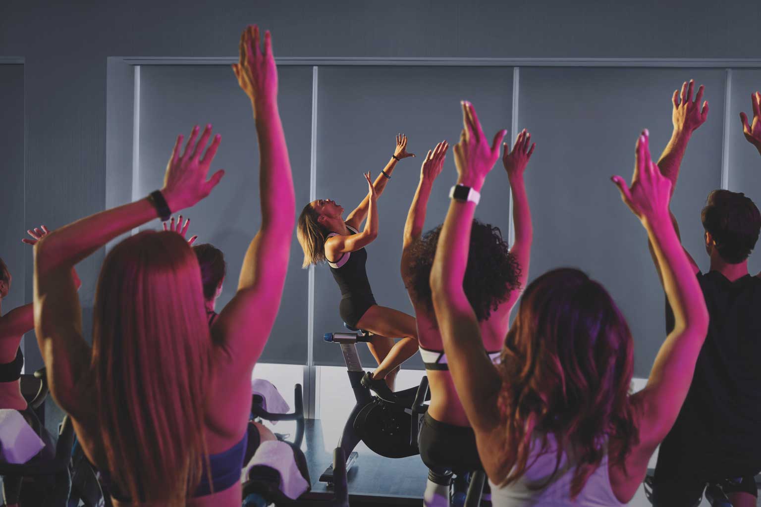 an image of an indoor cycling class with neon lights
