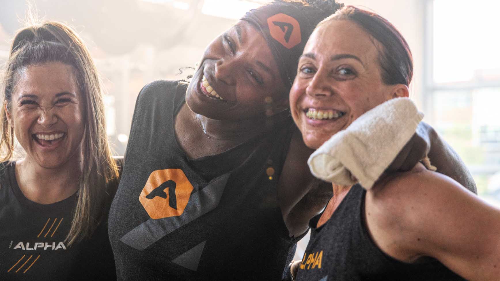 3 women smile with their arms around each other