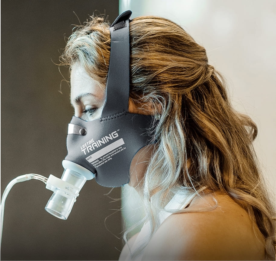 A close-up shot of a woman wearing the mask that is used for metabolic assessments. Her results will be used to inform both nutrition and training recommendations.