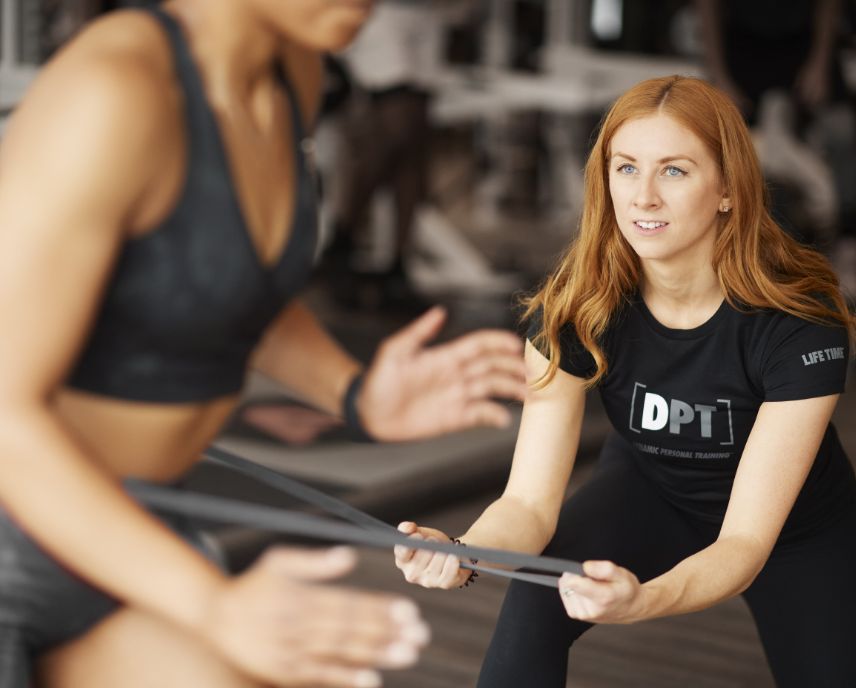 a trainer and client working with resistance bands in a workout