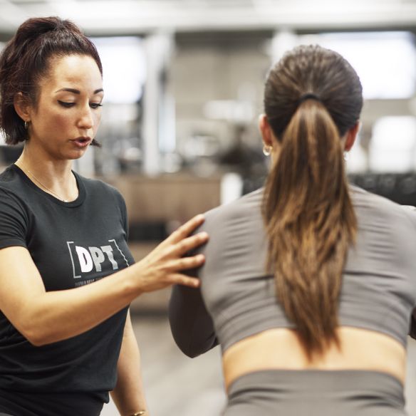 a trainer helping her client stretch