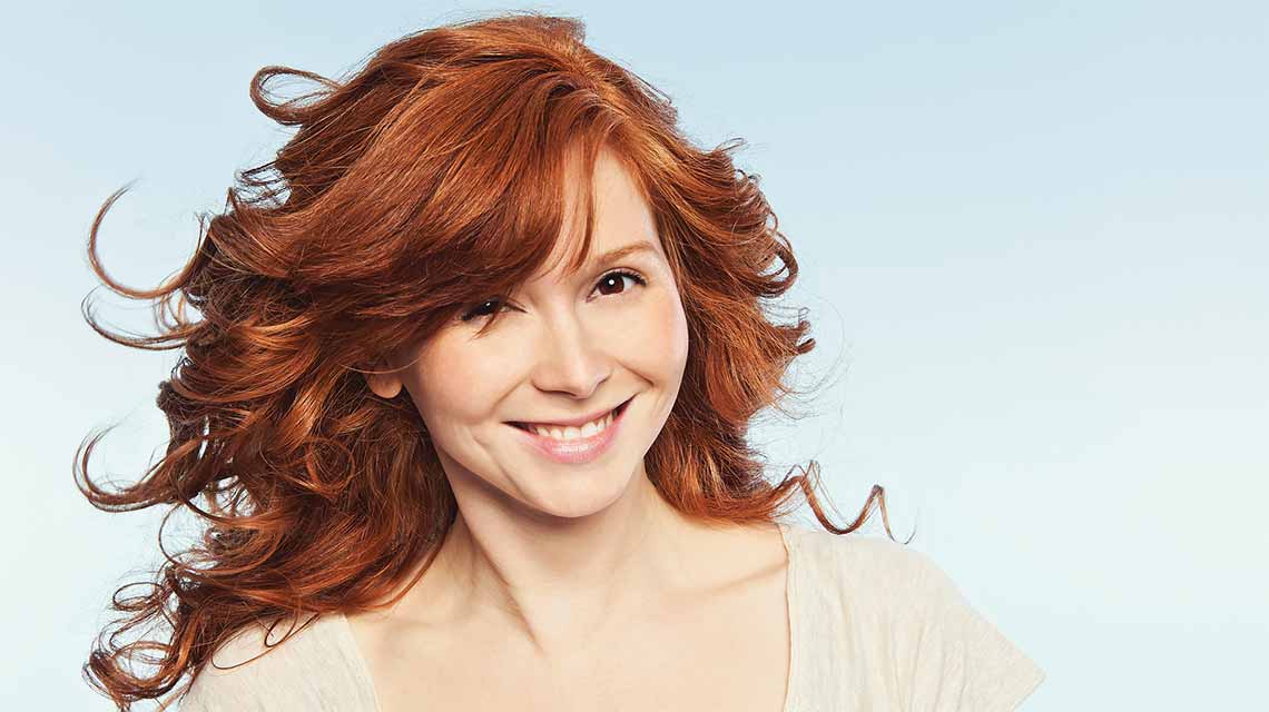 A woman with long, wavy hair flowing behind her in a breeze