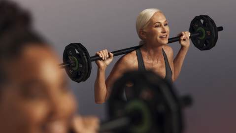 Life Time member squatting with a barbell during a Lift strength class