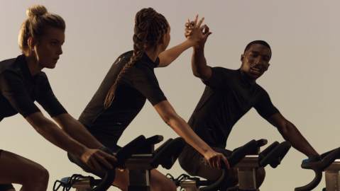 Cyclists in a PWR spin class at Life Time high fiving