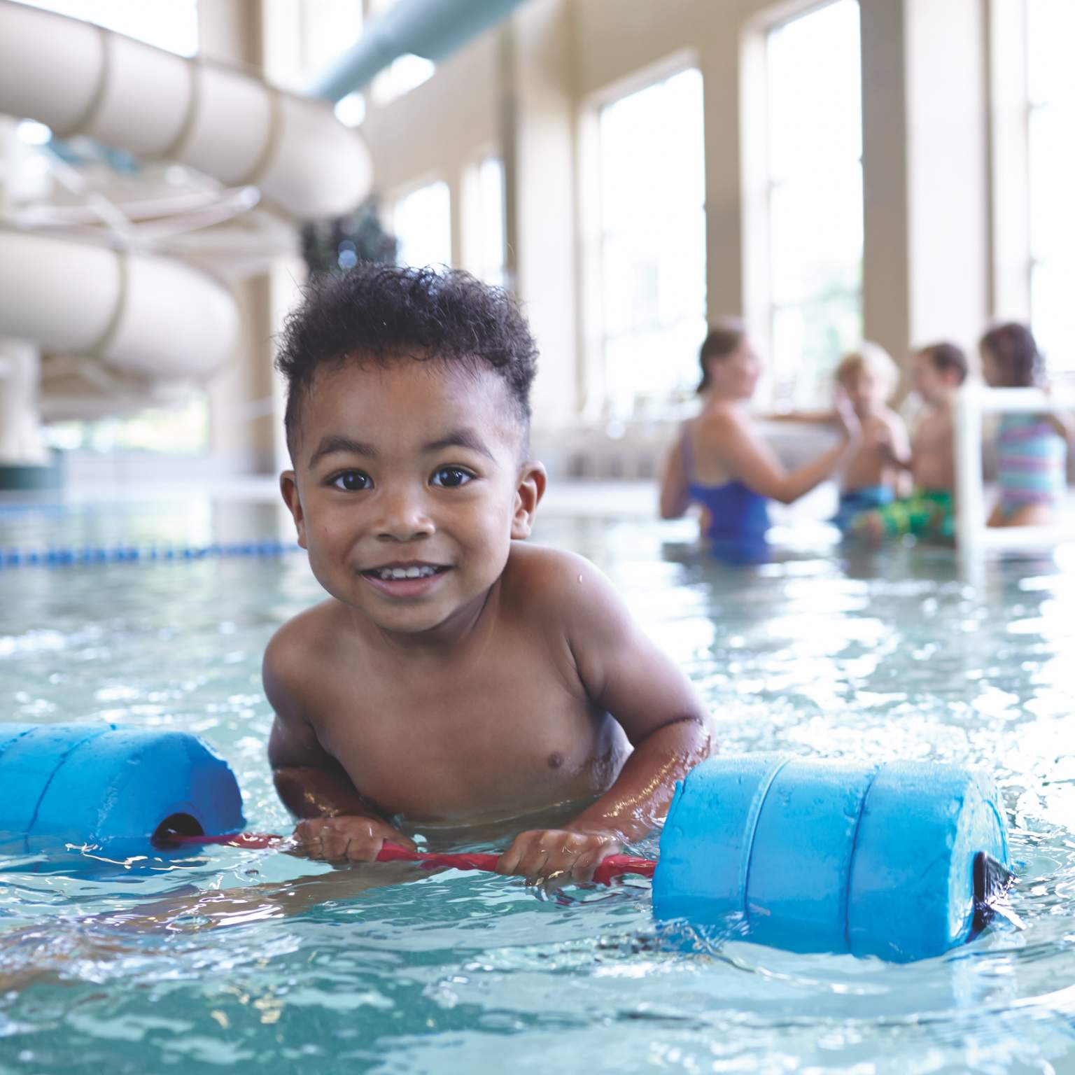 A toddler uses floating aid to learn how to swim at Life Time.