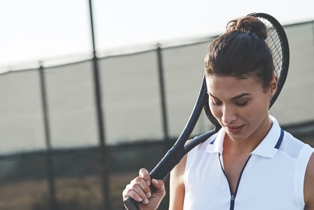 a women holding a tennis racket