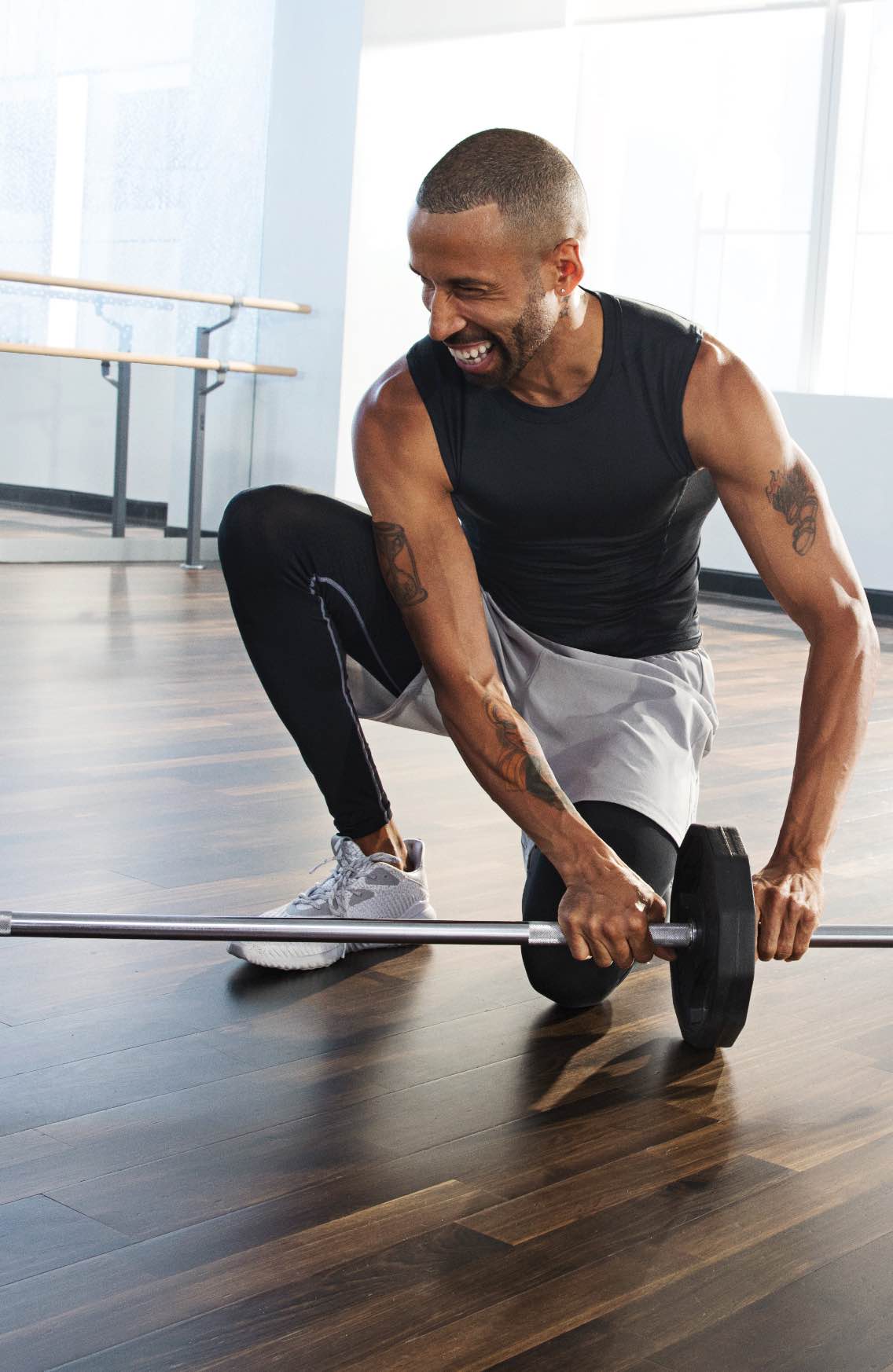 Man adjusting his barbell at a barbell strength group fitness class at Life Time. 