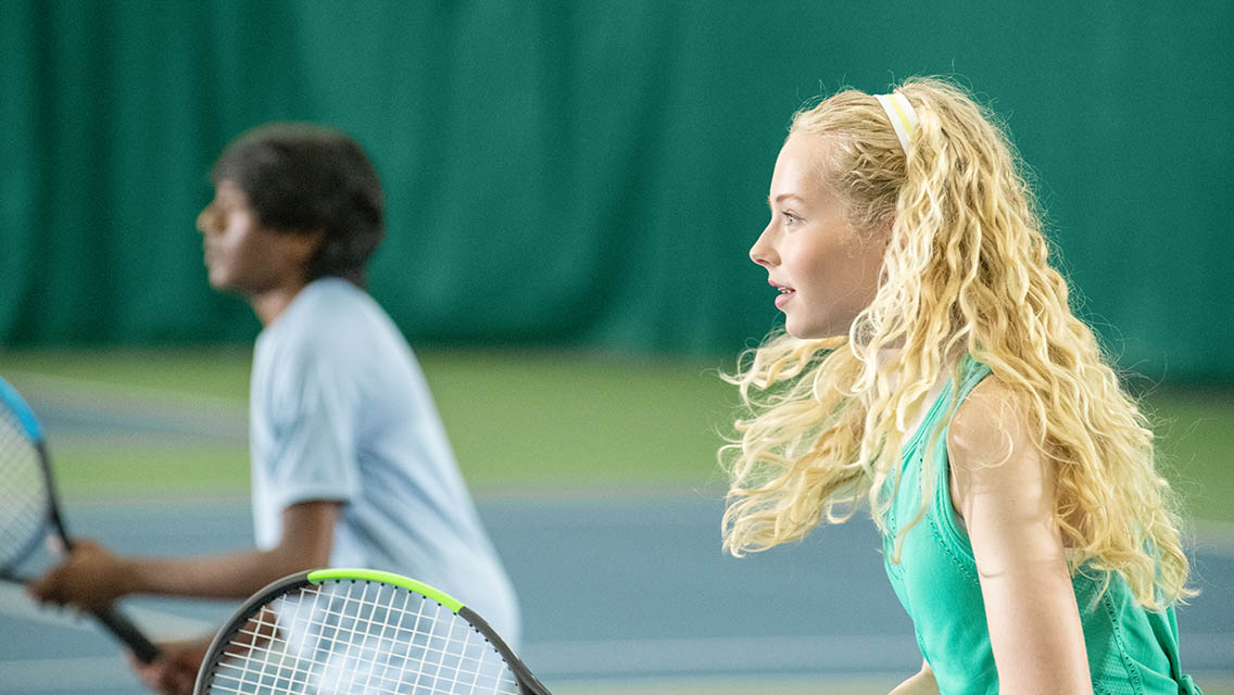 Two kids focused and playing tennis