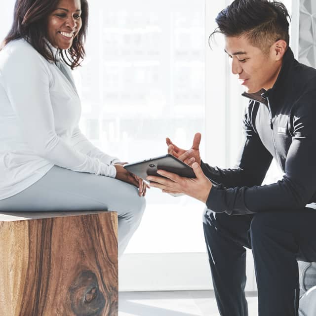 A Life Time trainer consults with his smiling client