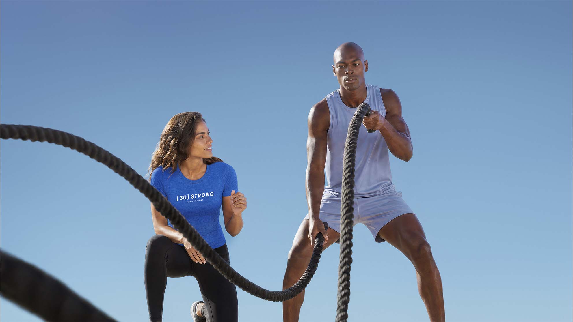 a trainer guides a female in a strength training move