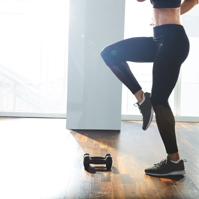 Man and woman doing high knees at Home with Life Time workouts