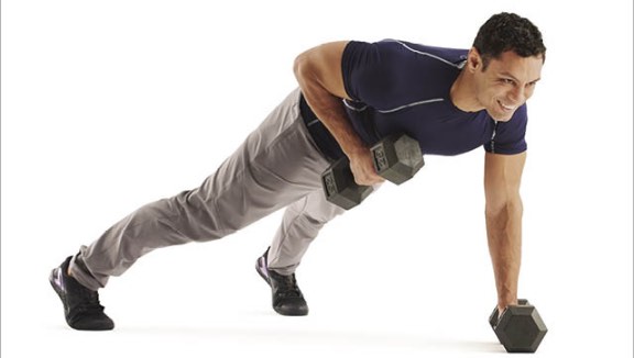 Man holding a plank position and using dumbbells to row