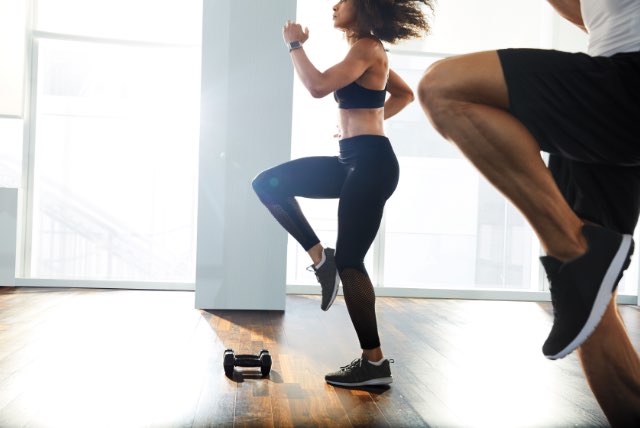 Two people running in place in a group fitness class at Life Time