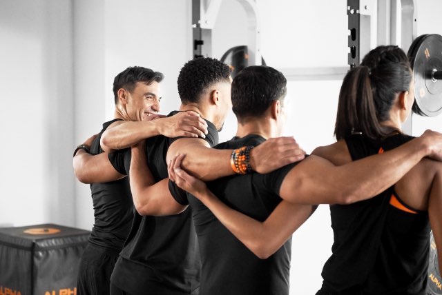 Four people with their arms around each other after a workout at Life Time