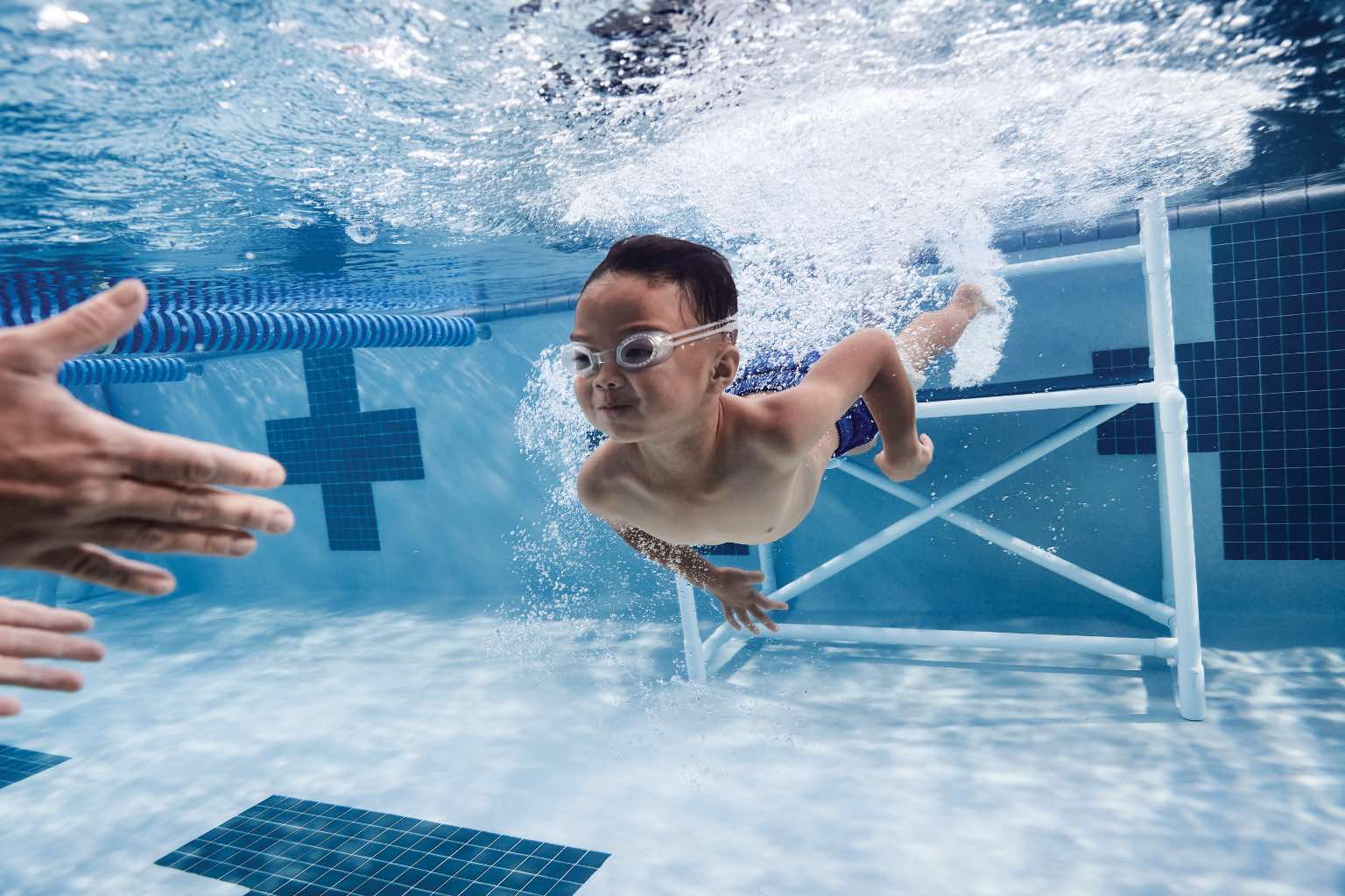 Little boy taking swim lessons at Life Time