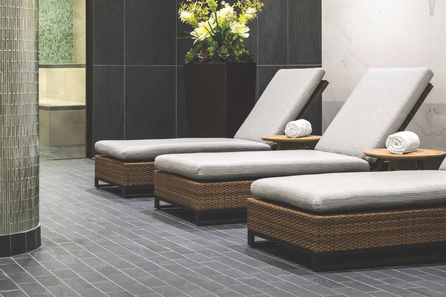 Three cushioned spa chairs in a luxury locker room at Life Time