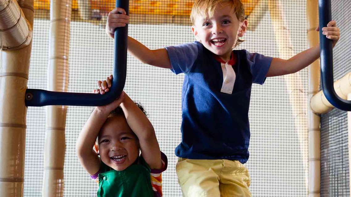 Two kids playing on an indoor playground