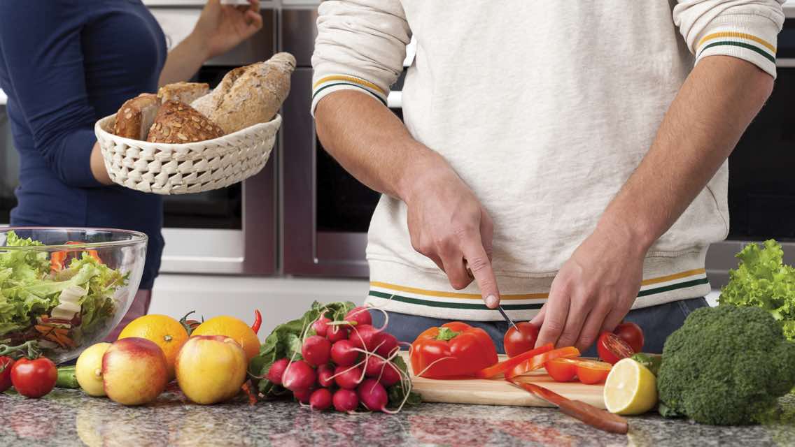 Person chopping fresh fruits and vegetables