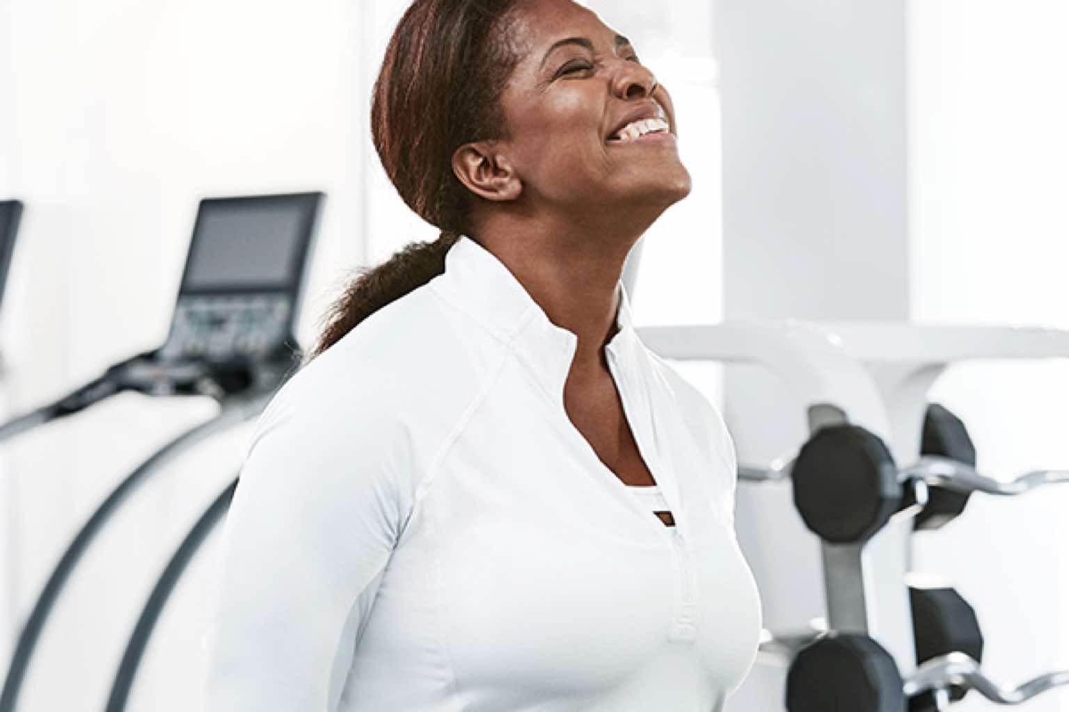 Smiling woman working out on the fitness floor at Life Time