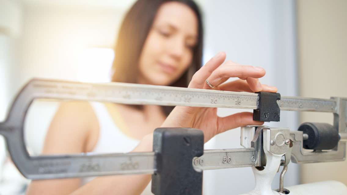 Woman weighing herself on a scale