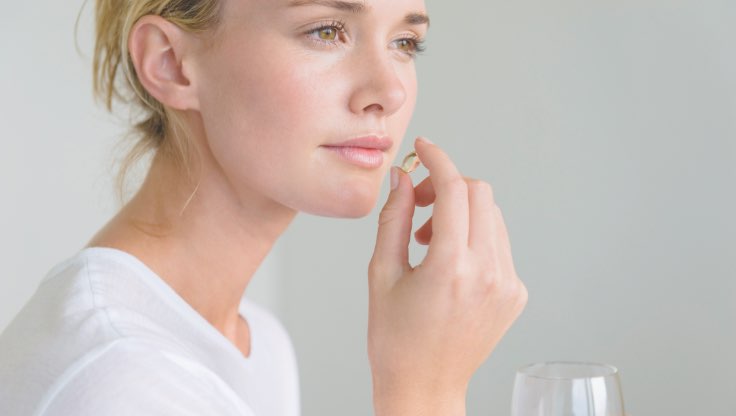 Woman taking a magnesium pill. 