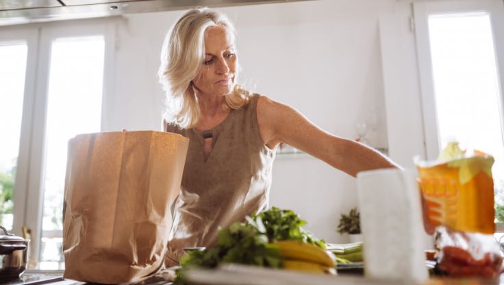 Woman unpacking her groceries at home. 