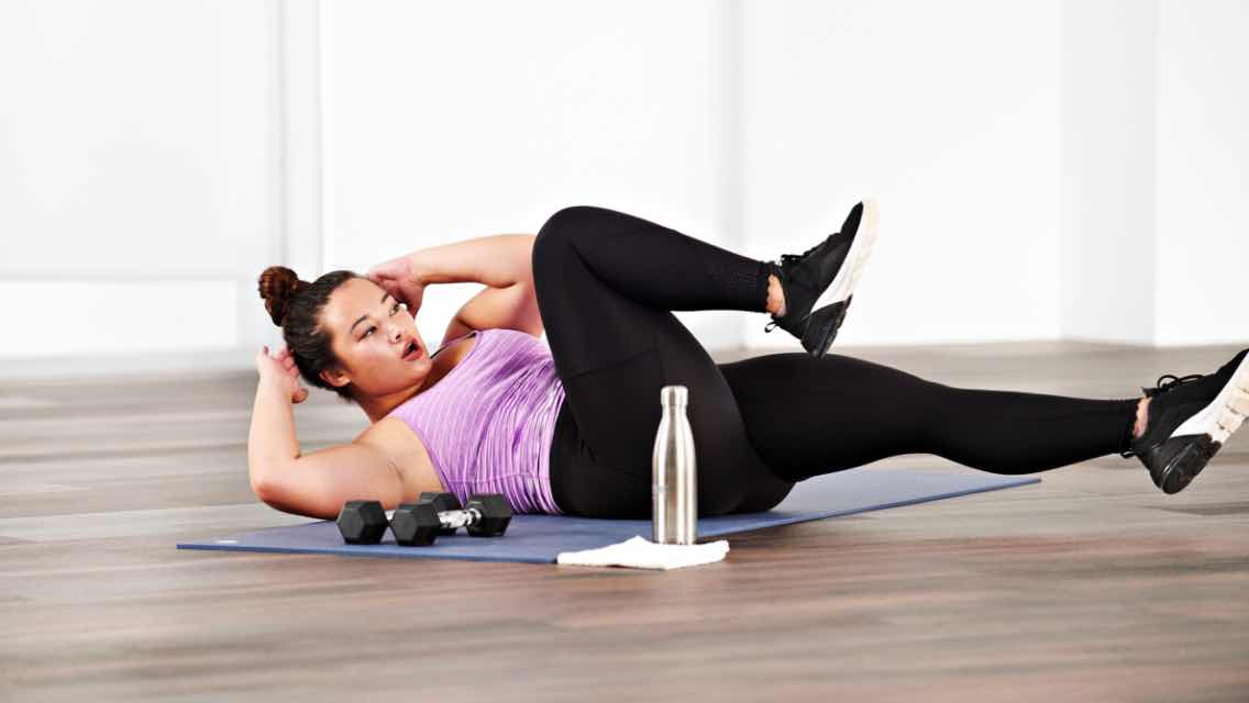 a woman taking an SHRED  class at home with Life Time Classes On Demand