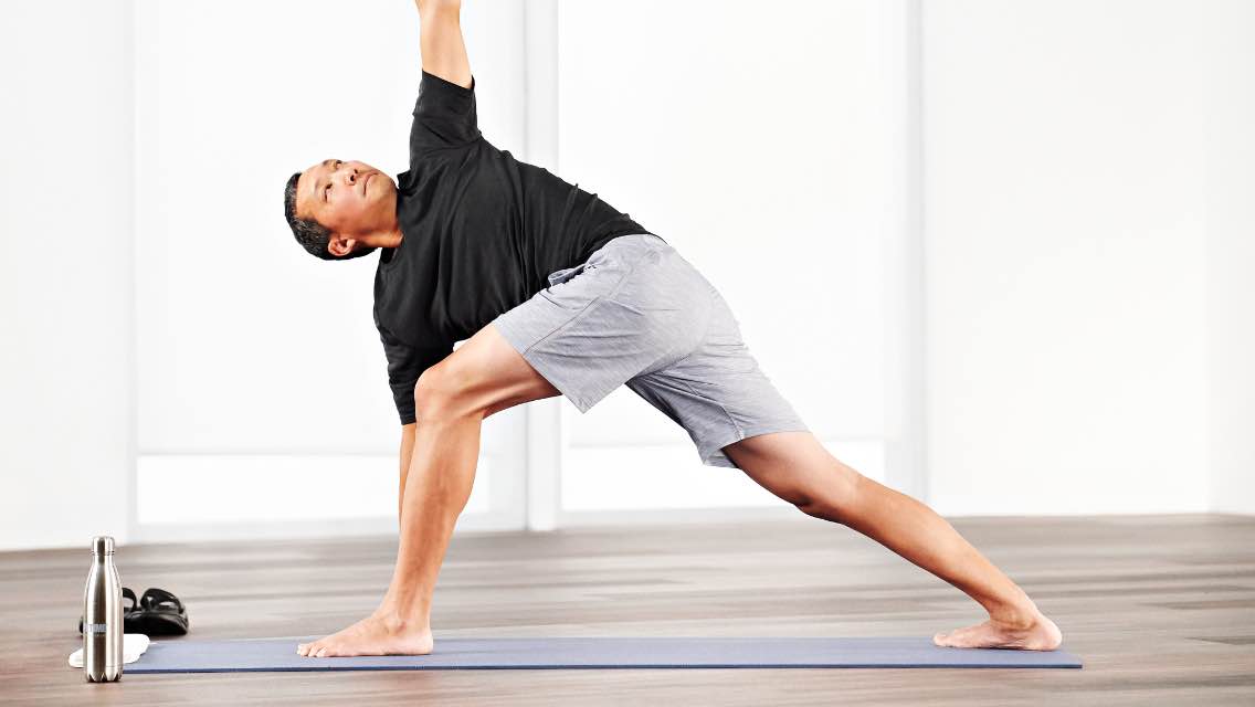 A man doing an at home yoga workout with Life Time Classes on demand