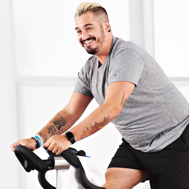Man taking a studio cycle class at home with Life Time Classes On Demand