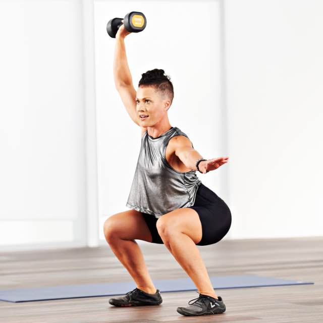 Woman taking a hit class at home with Life Time Classes On Demand