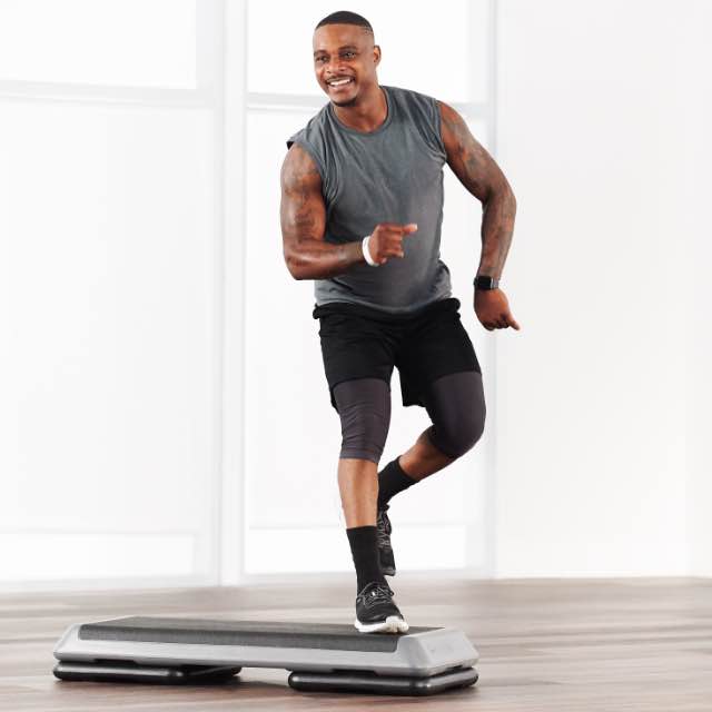 Man taking a step class at home with Life Time Classes On Demand