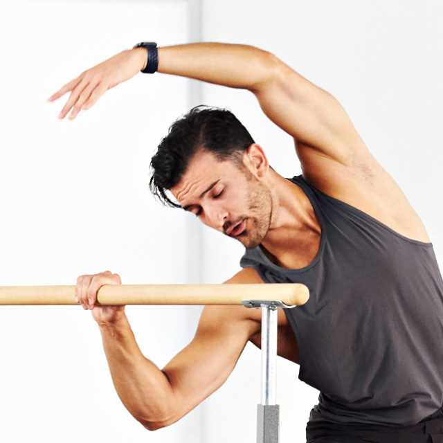 Man taking a Barre class at home with Life Time Classes On Demand