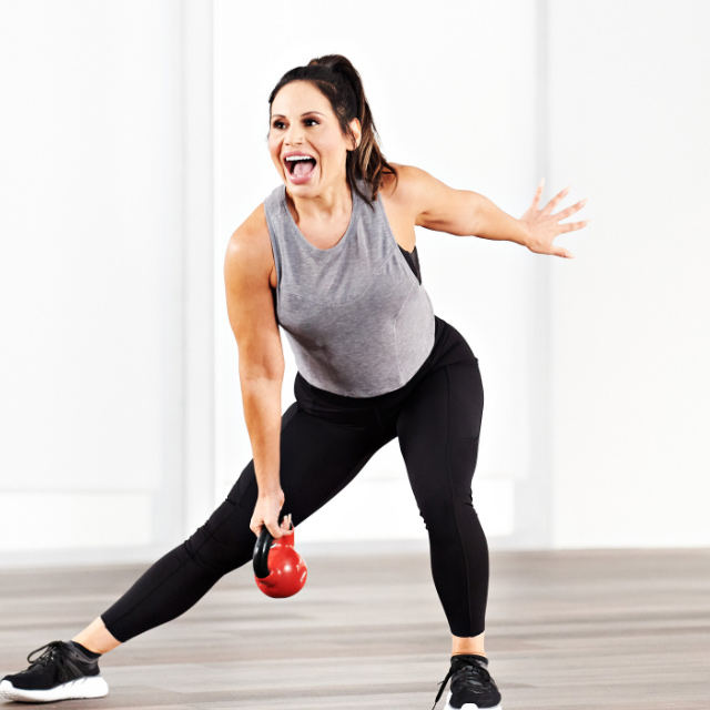 Woman taking a Kettlebell class at home with Life Time Classes On Demand